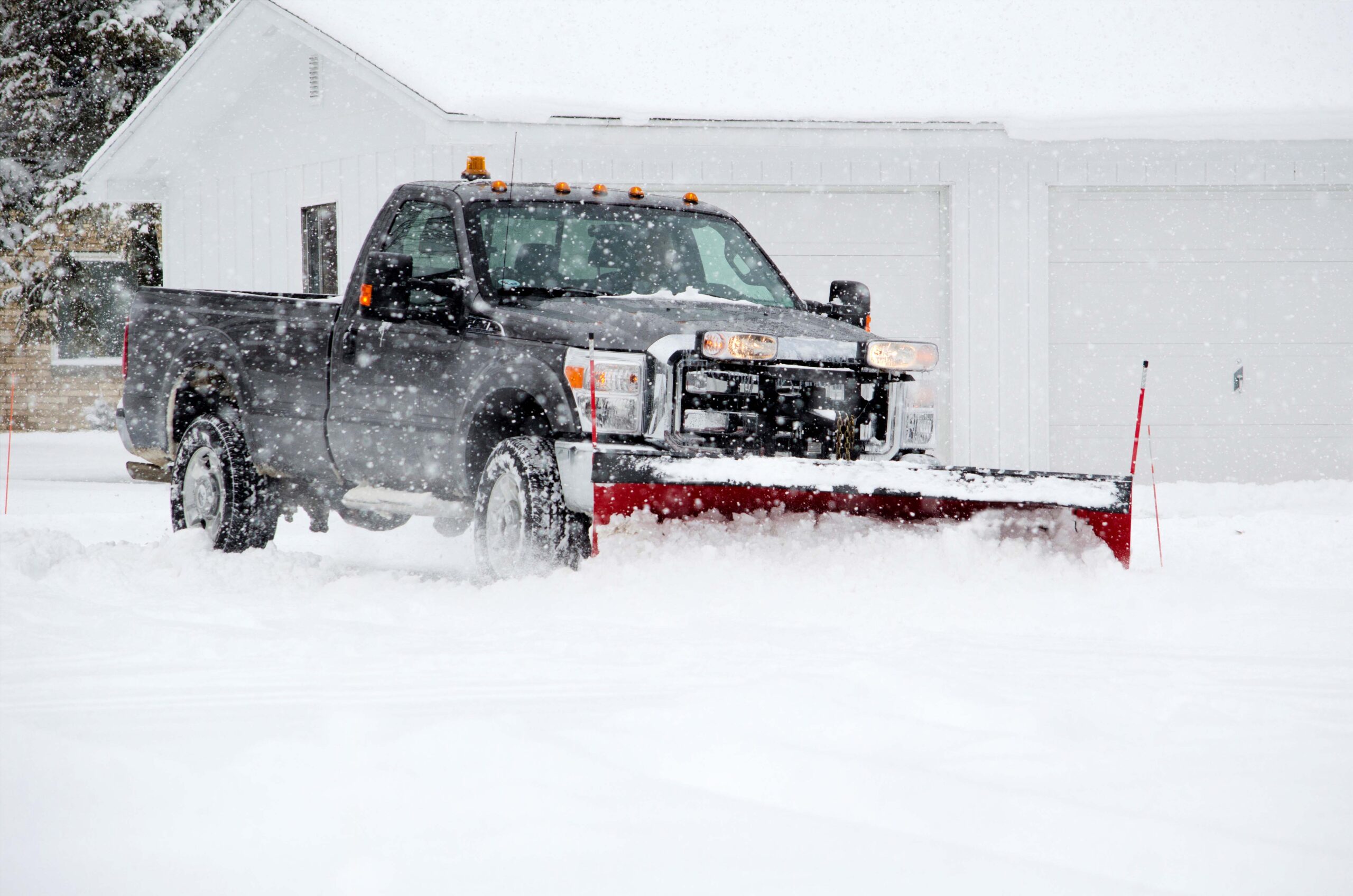 a worker plows heavy white snow during a Michigan winter